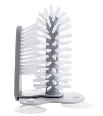 Rotating suction cup brush mounted on wall cleaning a glass