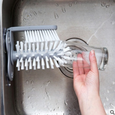 Suction cup brush attached to kitchen sink wall